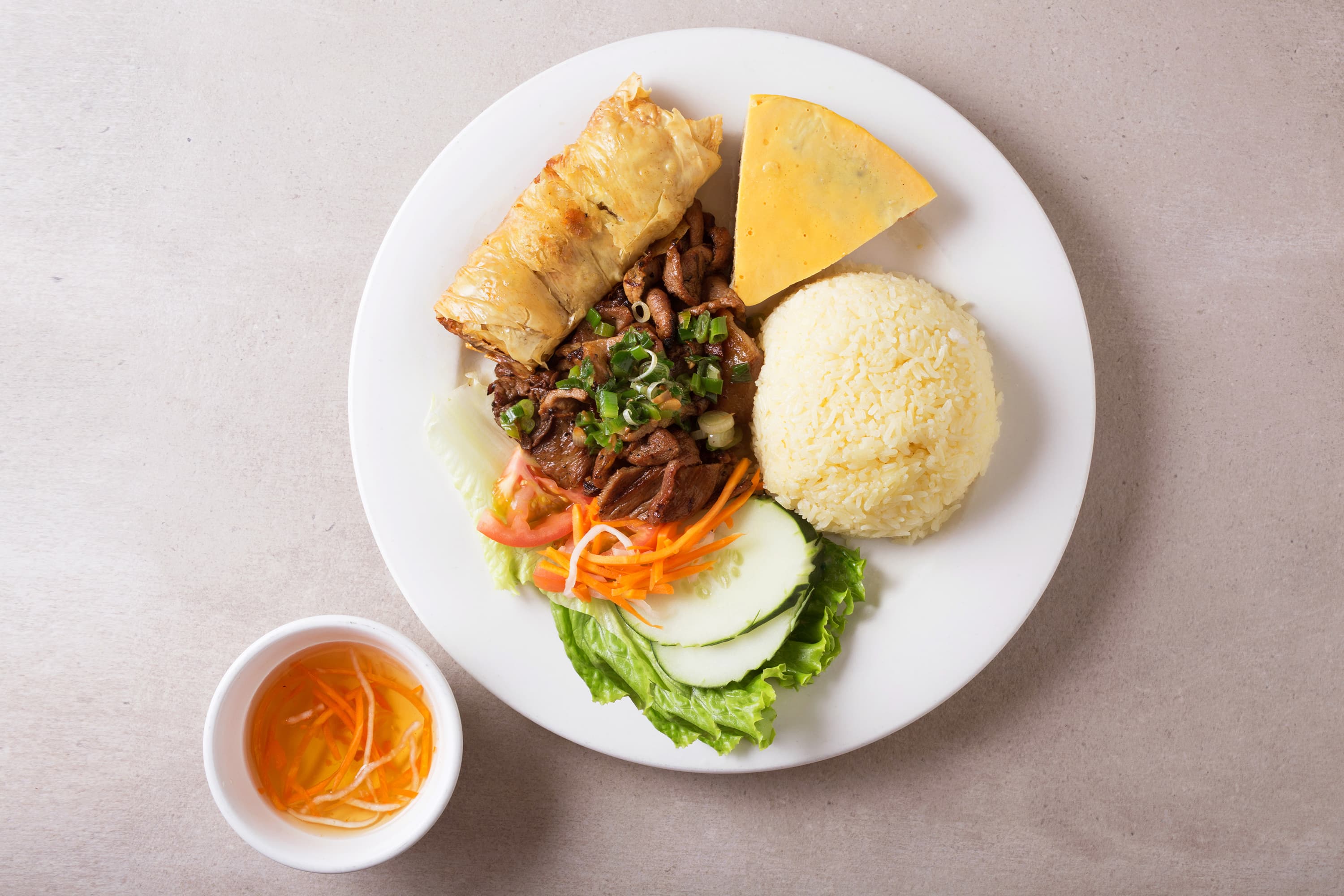 Rice plate with egg quiche, charbroiled pork, and shrimp patty in tofu skin