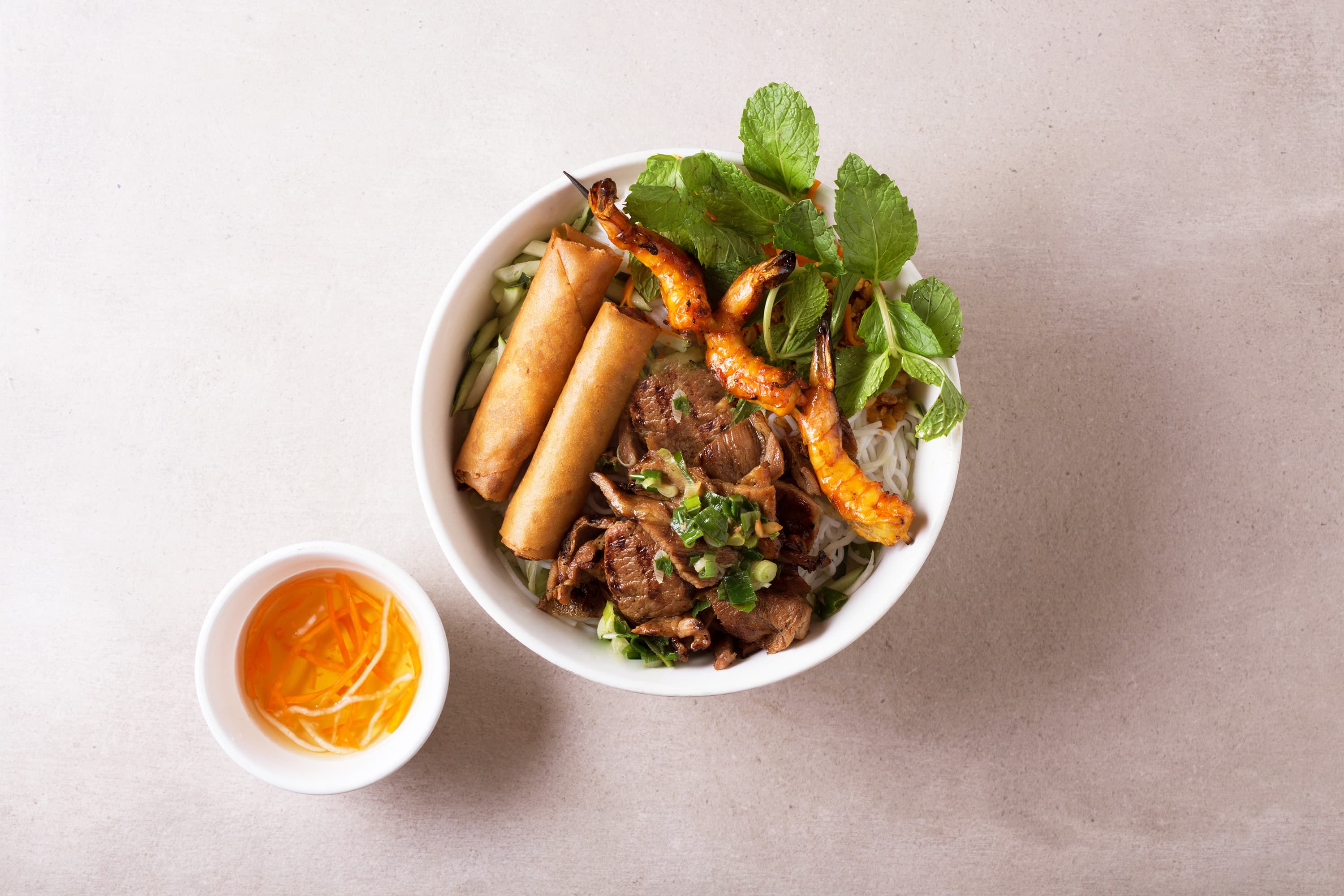 Vermicelli bowl with charbroiled pork, shrimp, fresh vegetables, and crispy egg rolls