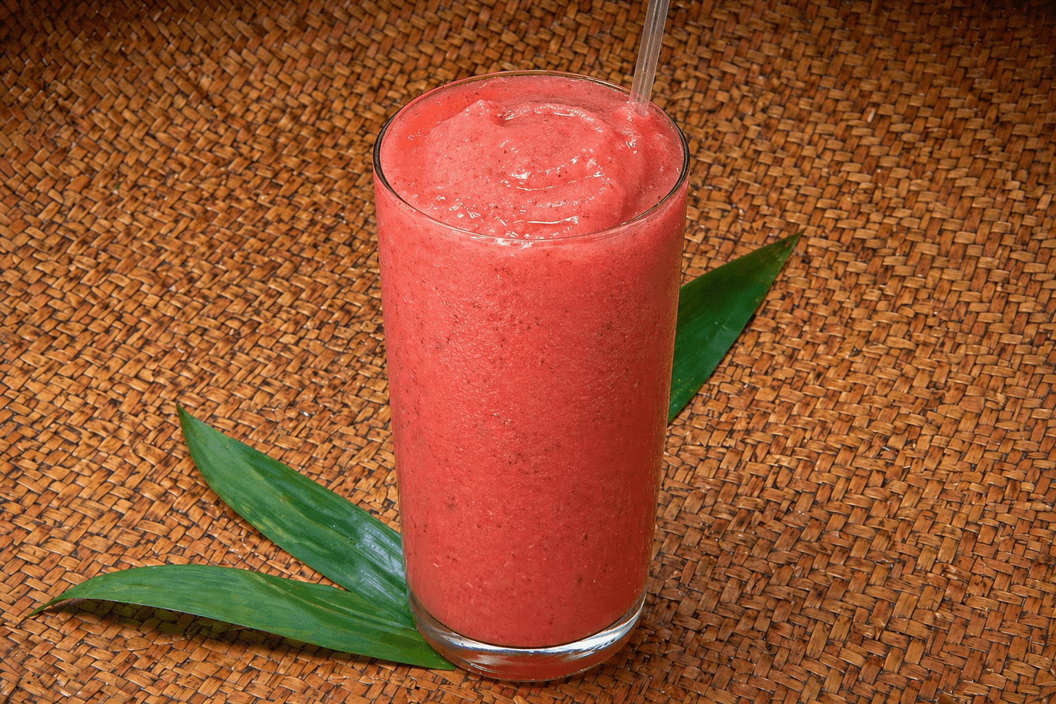 Strawberry smoothie in a clear cup with whipped topping